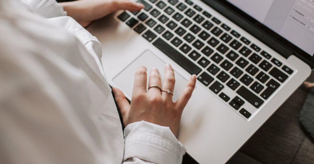 Qui sommes nous Woman working on a laptop indoors, focusing on document editing and remote work.